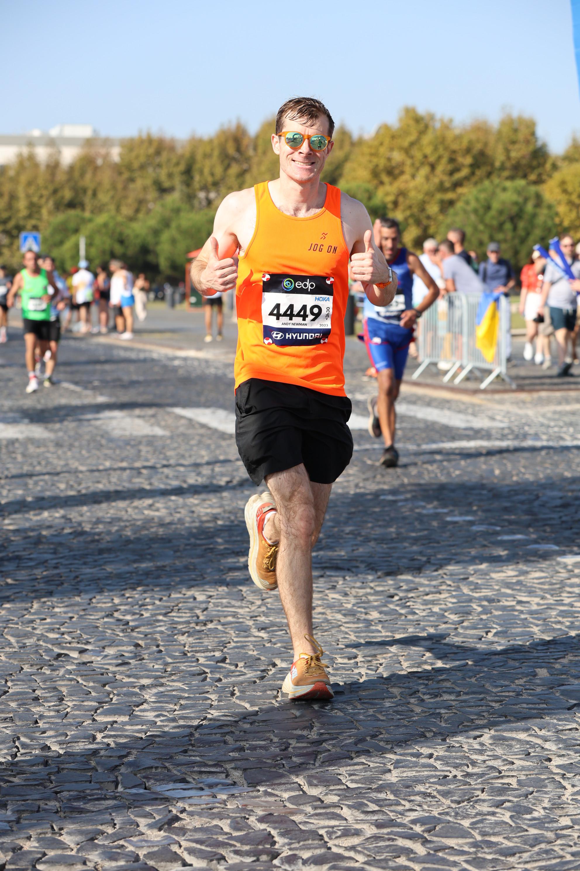 Andy Newman giving a thumbs up while running the Lisbon Marathon in October 2023